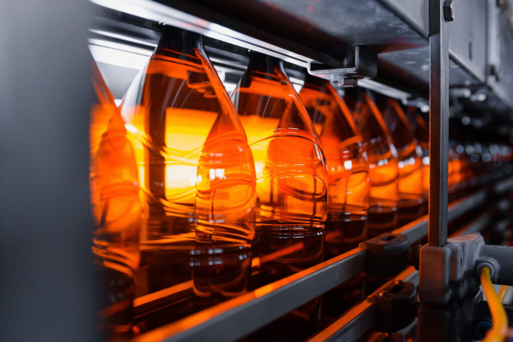 Plastic brown beer bottles on a conveyor belt close-up. Production of plastic bottles.